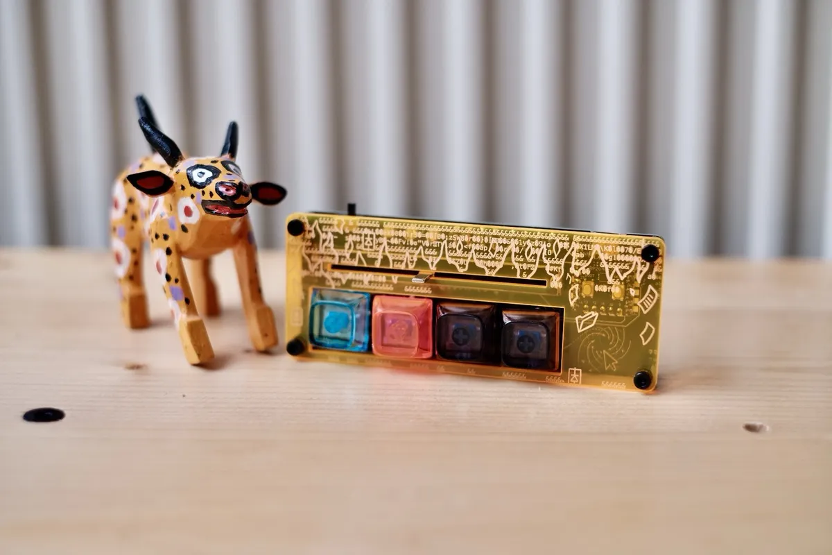 A Disarray Desnarler in a yellow engraved acrylic case standing on a wooden table next to a painted wooden bull figurine.
